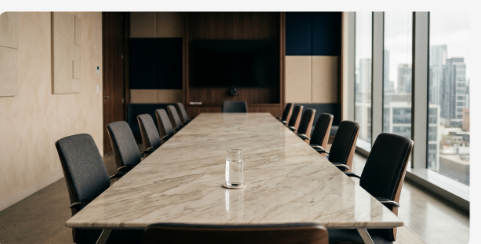 A long boardroom table in a bright city office